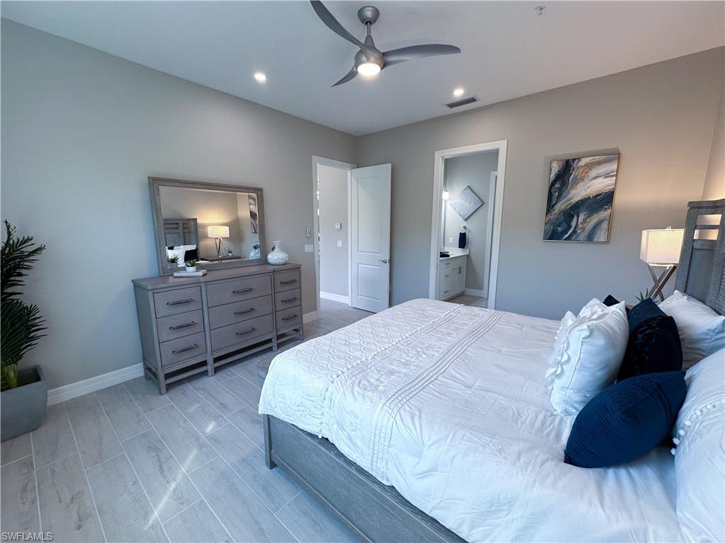 262 Indies Drive East, Unit 201 Naples, FL 34114 - Photo 19 of 45 a bed room with a bed and a television