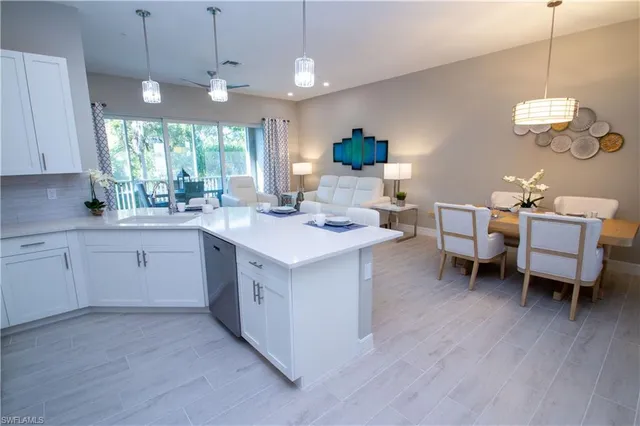 a kitchen with a sink dishwasher a dining table and chairs with wooden floor