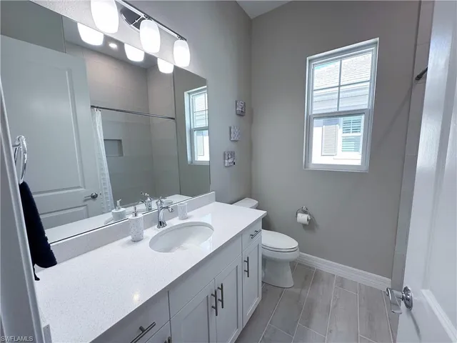 a bathroom with a sink vanity mirror and toilet