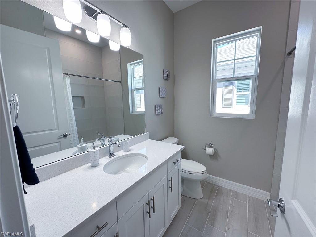 262 Indies Drive East, Unit 201 Naples, FL 34114 - Photo 29 of 45 a bathroom with a sink vanity mirror and toilet