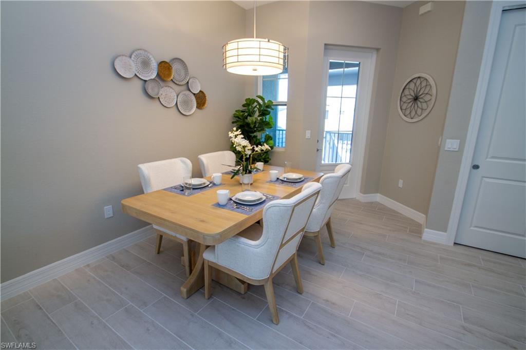 262 Indies Drive East, Unit 201 Naples, FL 34114 - Photo 6 of 45 a view of a dining room with furniture window and wooden floor