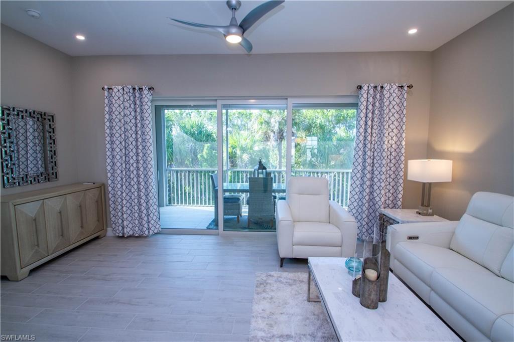 262 Indies Drive East, Unit 201 Naples, FL 34114 - Photo 7 of 45 a living room with furniture and a large window