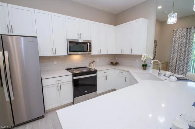 a kitchen with stainless steel appliances a refrigerator sink and microwave