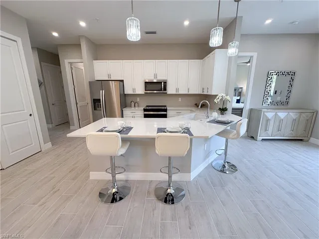 an open kitchen with dining table and stainless steel appliances