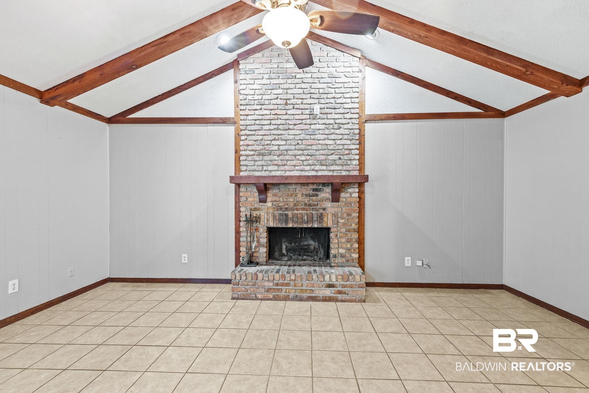 4151 Springdale Road Mobile, AL 36609 - Photo 5 of 21 Unfurnished living room with lofted ceiling with beams, a brick fireplace, wood walls, and ceiling fan