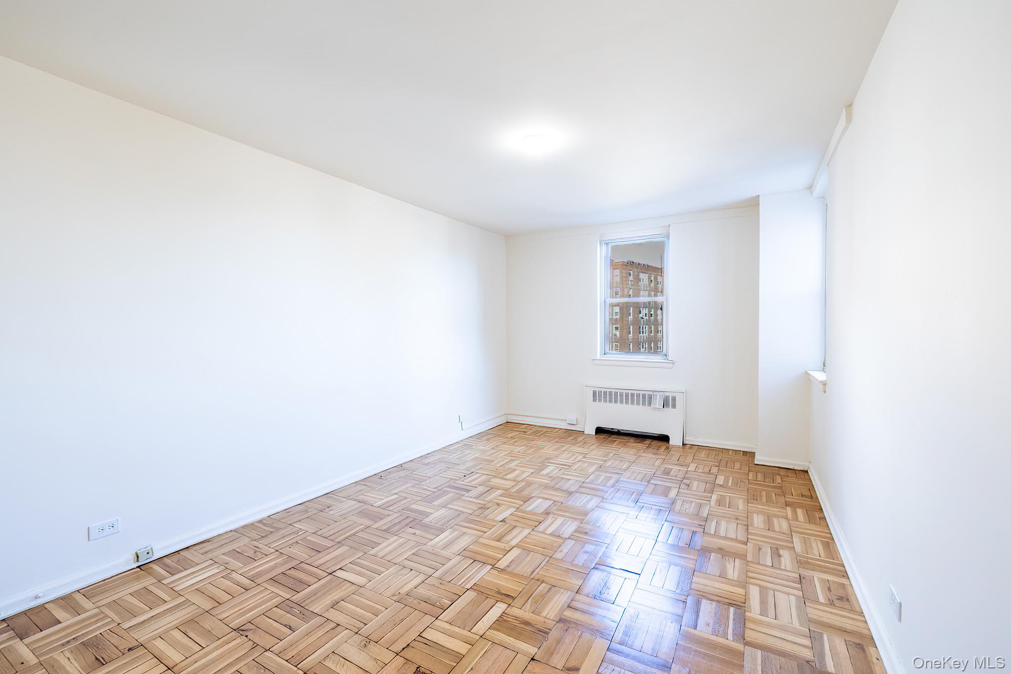25 Knolls Crescent, Unit 9E Bronx, NY 10463 - Photo 15 of 23 Empty room featuring radiator heating unit and baseboards