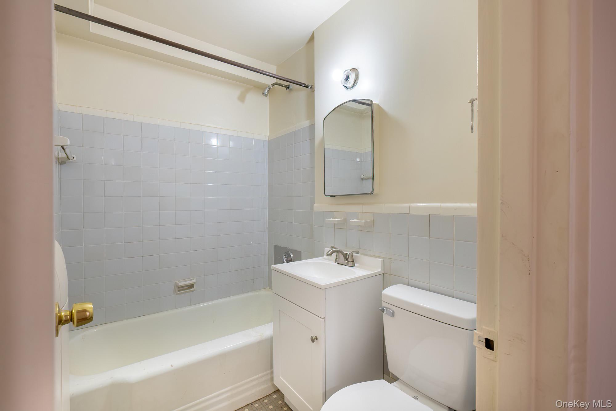 25 Knolls Crescent, Unit 9E Bronx, NY 10463 - Photo 16 of 23 Bathroom featuring shower / washtub combination, vanity, and tile walls