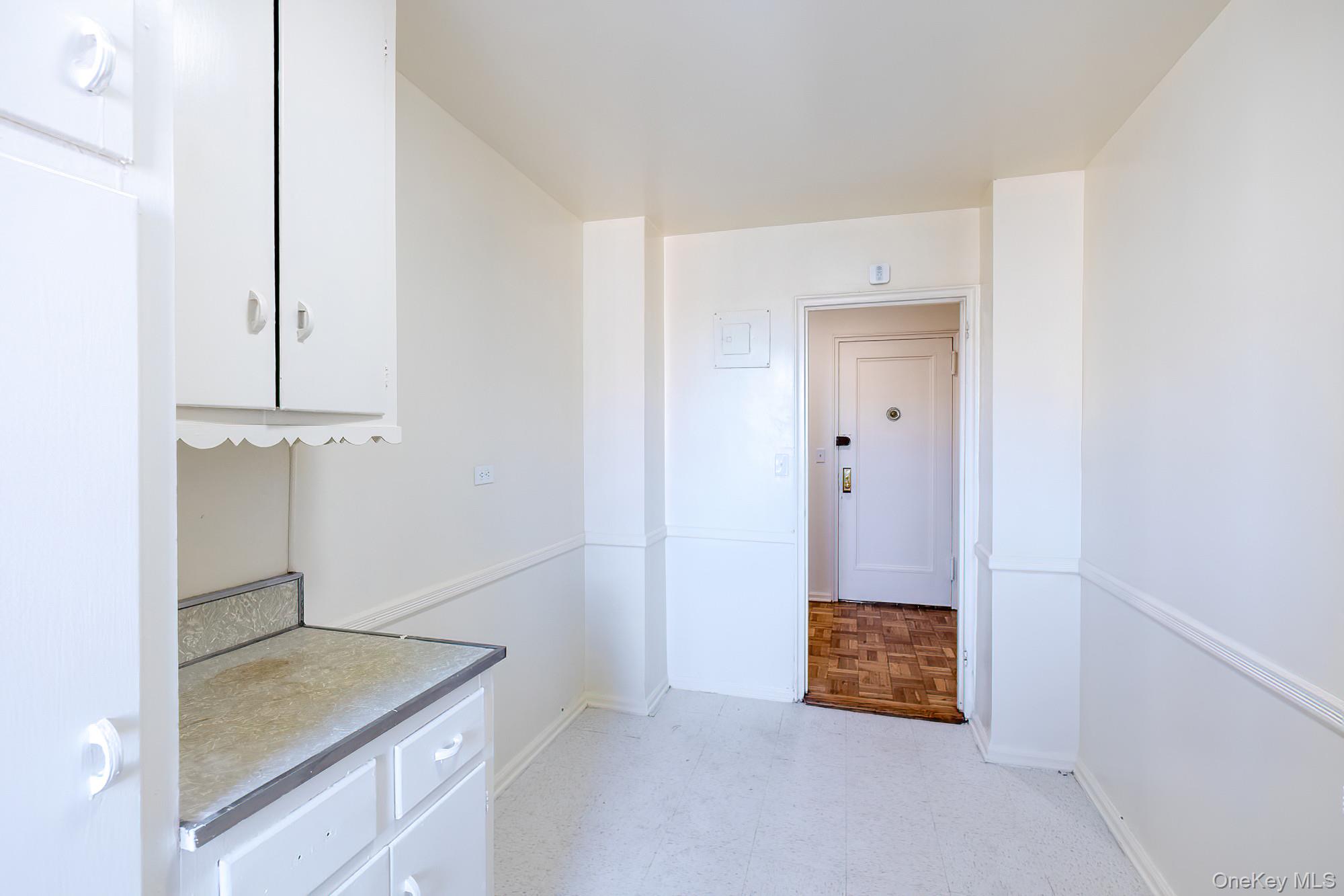 25 Knolls Crescent, Unit 9E Bronx, NY 10463 - Photo 6 of 23 Kitchen featuring white cabinetry, light floors, and light countertops
