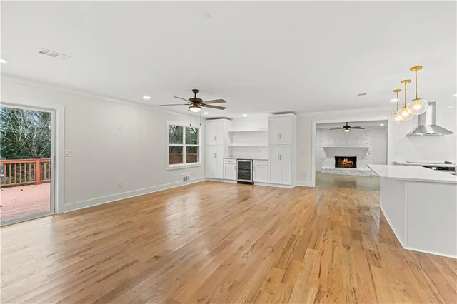 an empty room with wooden floor and a ceiling fan