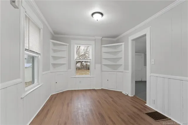 an empty room with wooden floor and window