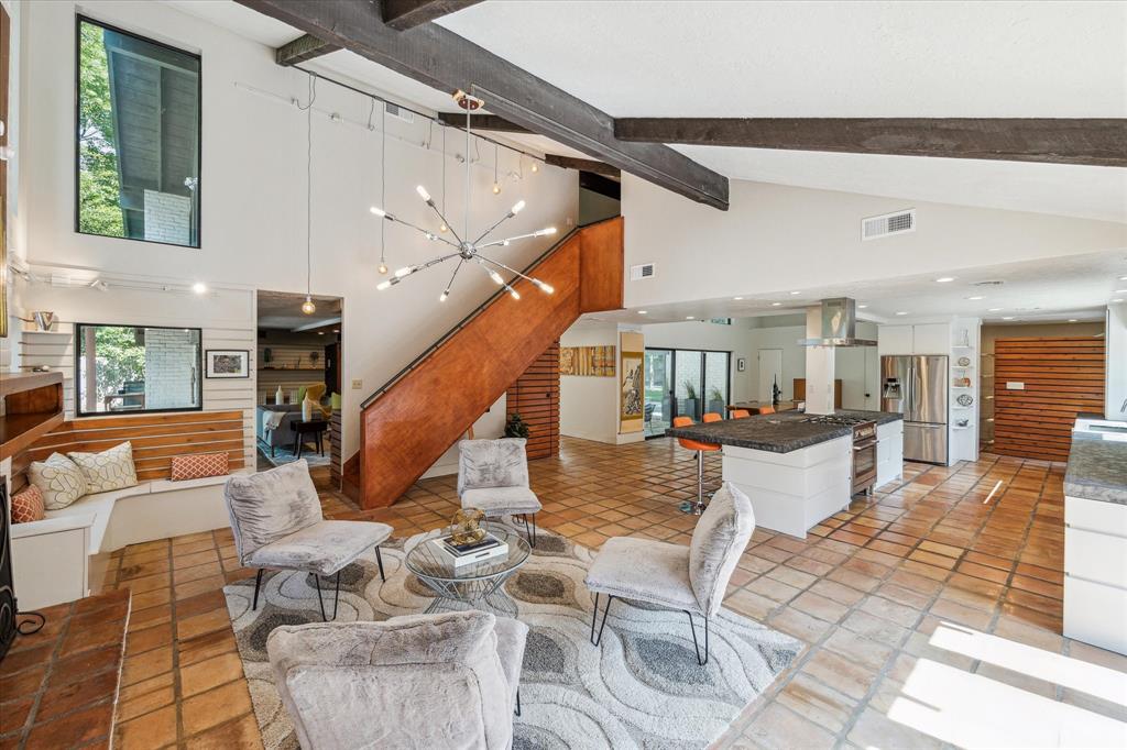 This light-filled home features vaulted ceilings, decorative wood beams, rich wood accents, and an abundance of windows that invite in plenty of natural light.