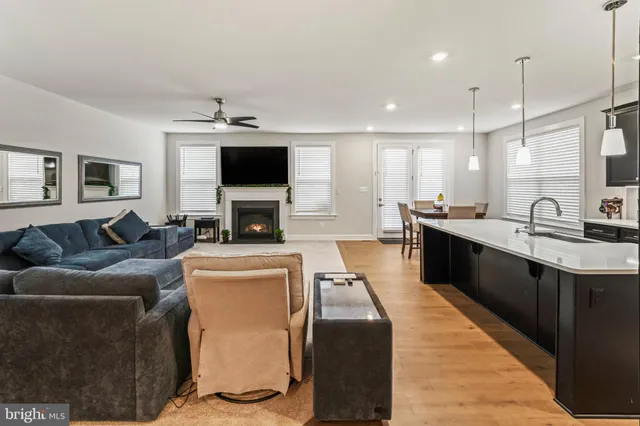 a kitchen with stainless steel appliances granite countertop a sink counter space and living room view