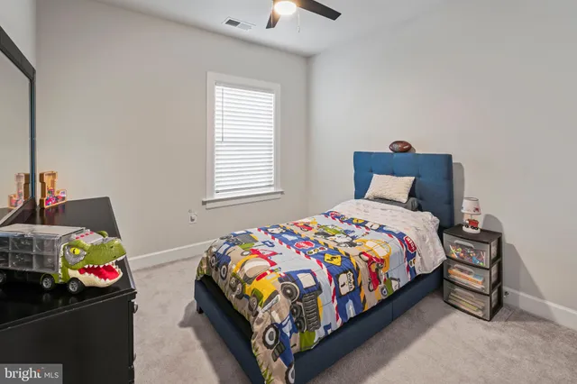 a bedroom with a bed and a flat tv screen on the dresser