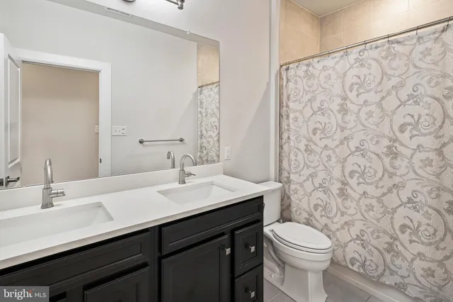 a bathroom with double vanity sinks and a large mirror