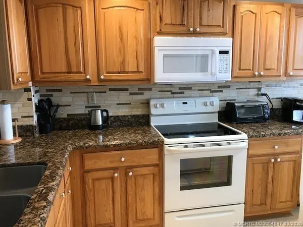 a kitchen with stainless steel appliances granite countertop a sink stove and cabinets