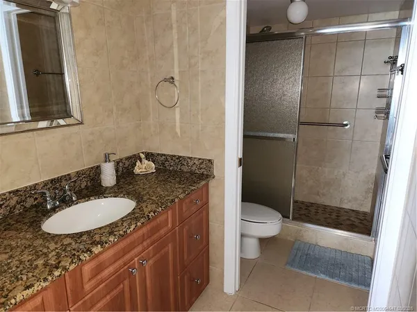 a white toilet sitting next to a shower