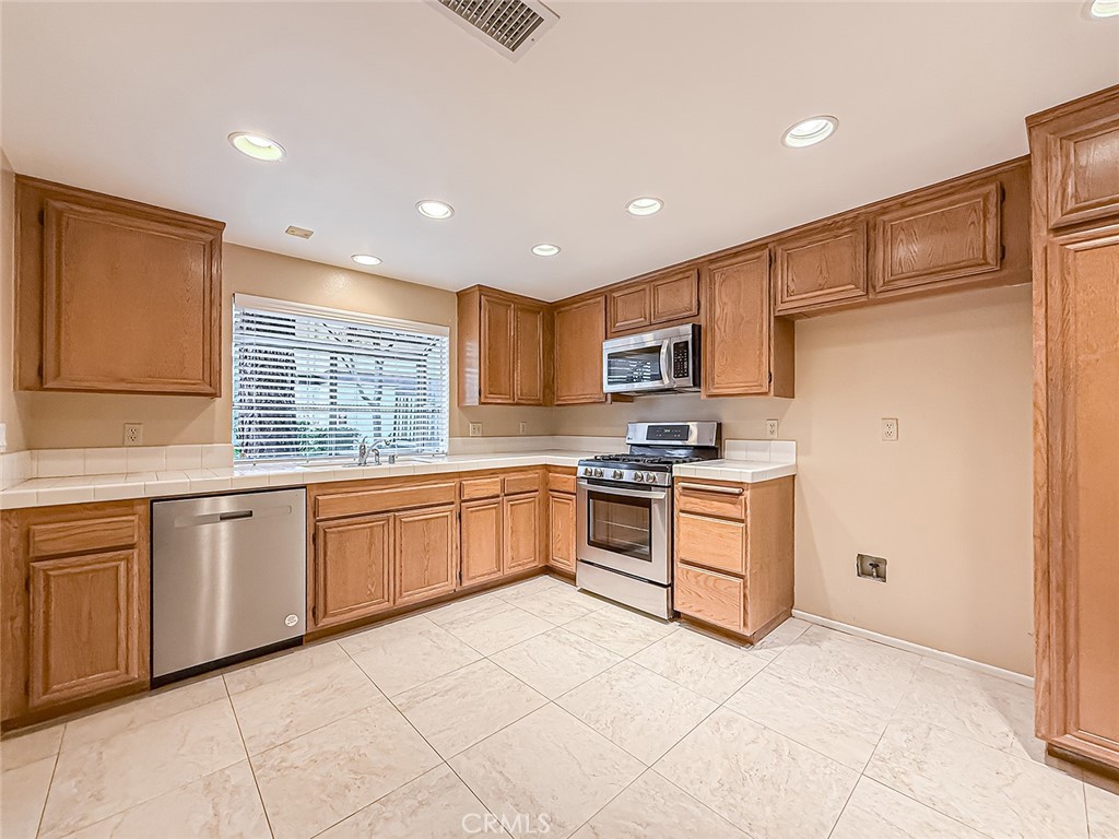 5542 Las Virgenes Road, Unit 97 Calabasas, CA 91302 - Photo 14 of 50 a kitchen with granite countertop a stove top oven sink and cabinets