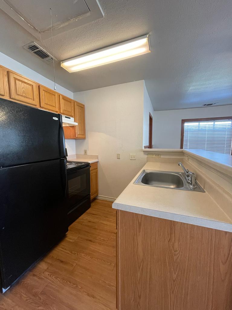108 Austin Street, Unit B Kyle, TX 78640 - Photo 5 of 14 Functional kitchen with ample cabinet space and a practical breakfast bar.