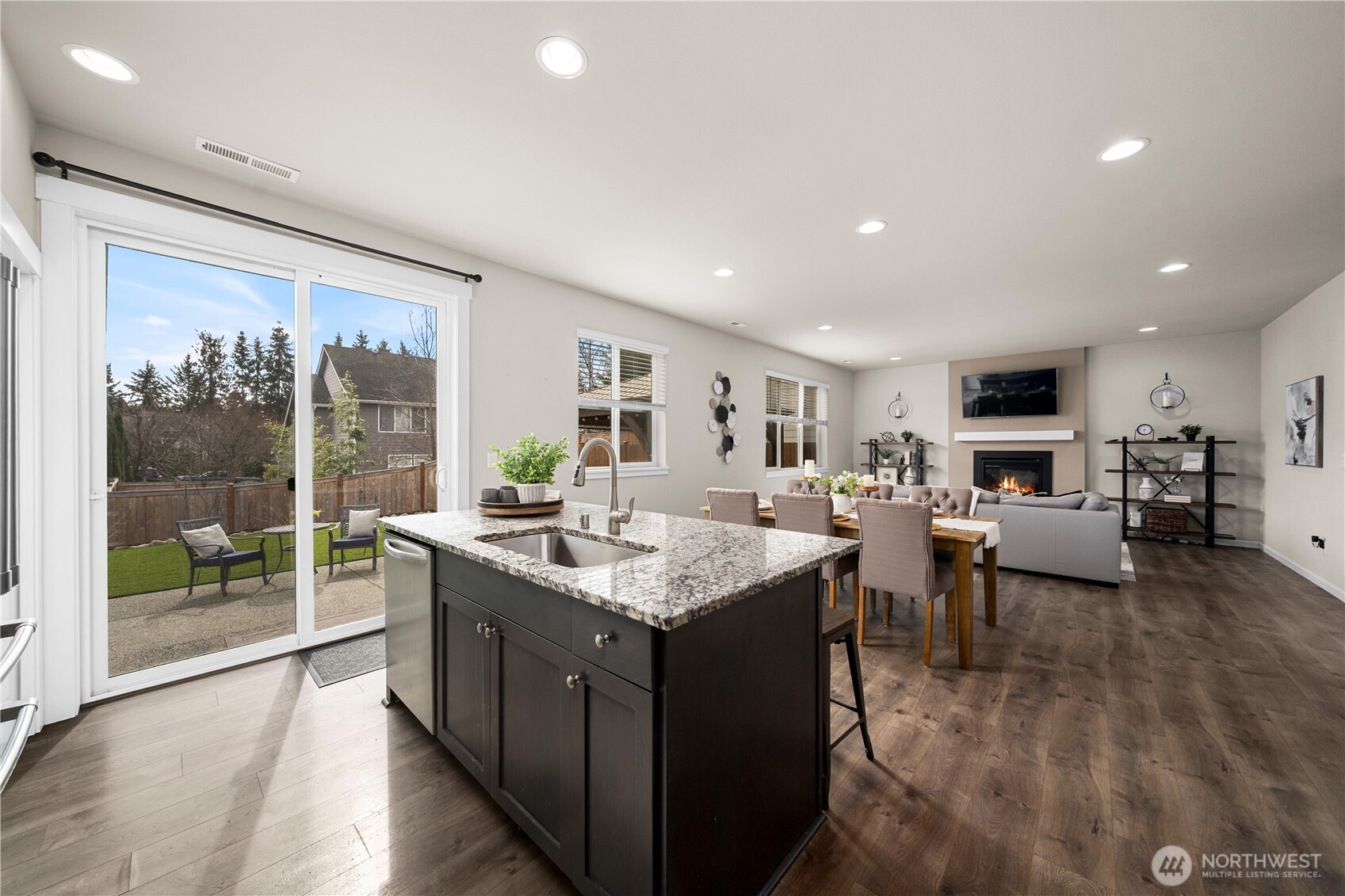 26239 227th Terrace Southeast Maple Valley, WA 98038 - Photo 10 of 37 a open kitchen with stainless steel appliances granite countertop a stove top oven a sink dishwasher a dining table and chairs with wooden floor