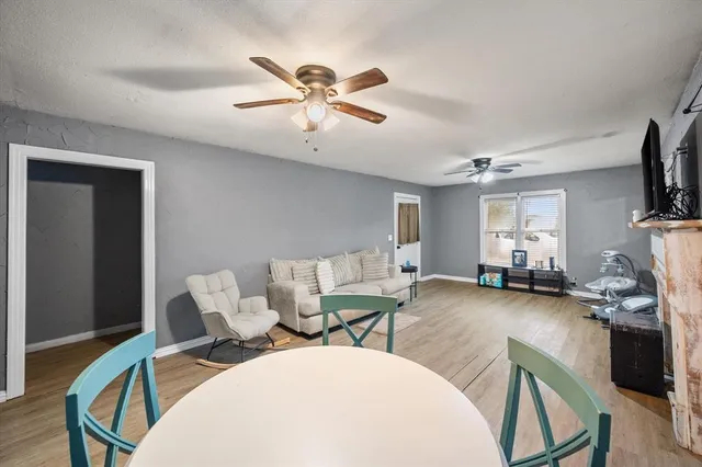 a living room with furniture a flat screen tv and a chandelier