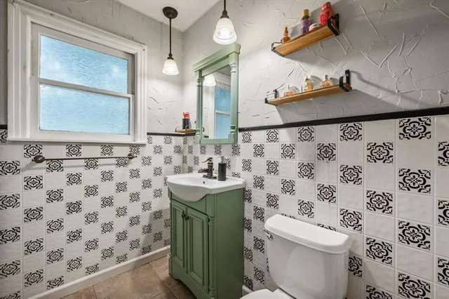 a bathroom with a sink a toilet and a mirror