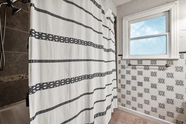 a bathroom with a window and a shower