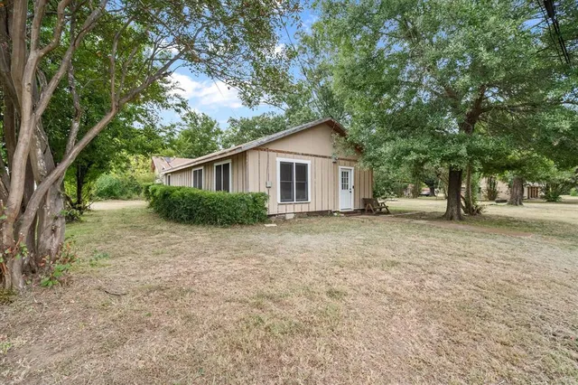 a view of an house with backyard space and tree