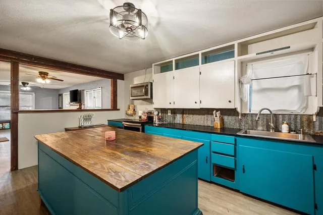 a living room with granite countertop kitchen island stainless steel appliances and a counter space