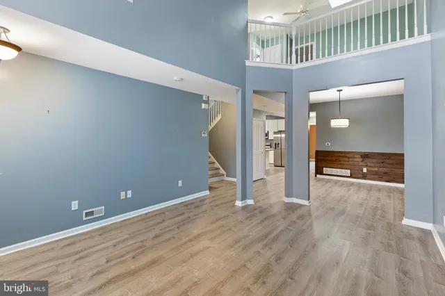 a view of a hallway with wooden floor and staircase