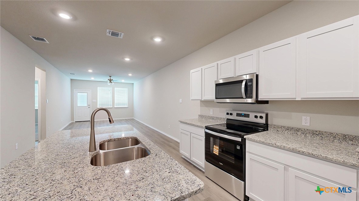 1110 Stone Vly Road Temple, TX 76502 - Photo 14 of 21 a kitchen with sink a microwave a stove and refrigerator