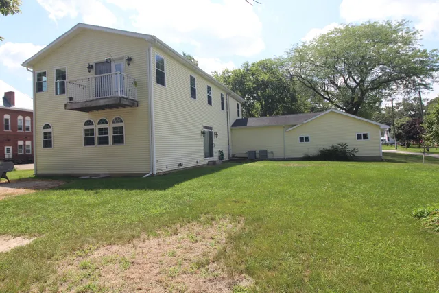 a view of a house with backyard and trees