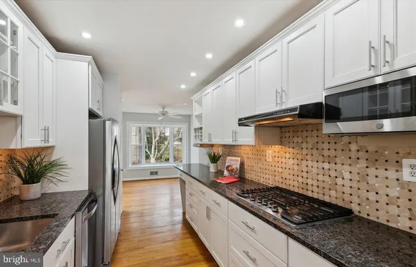 a kitchen with stainless steel appliances granite countertop a stove and a refrigerator