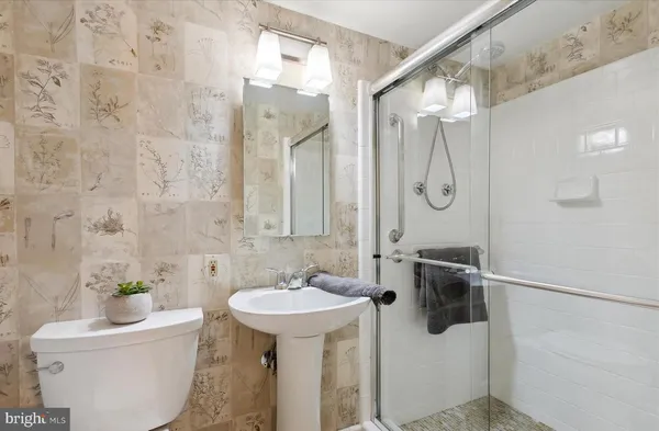 a bathroom with a sink and mirror with toilet