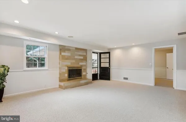 a view of an empty room with a fireplace and a window