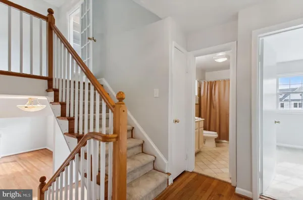 a view of a hallway with wooden floor and staircase