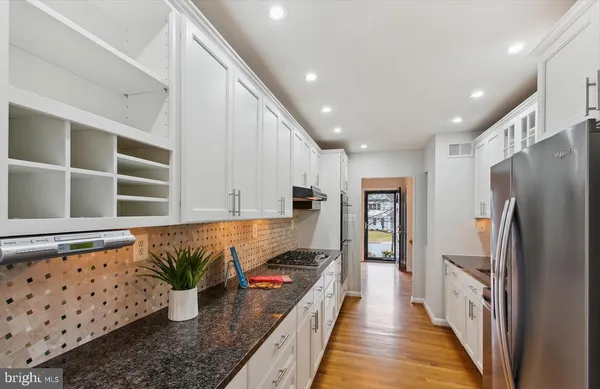 a kitchen with stainless steel appliances granite countertop a refrigerator a stove and a refrigerator
