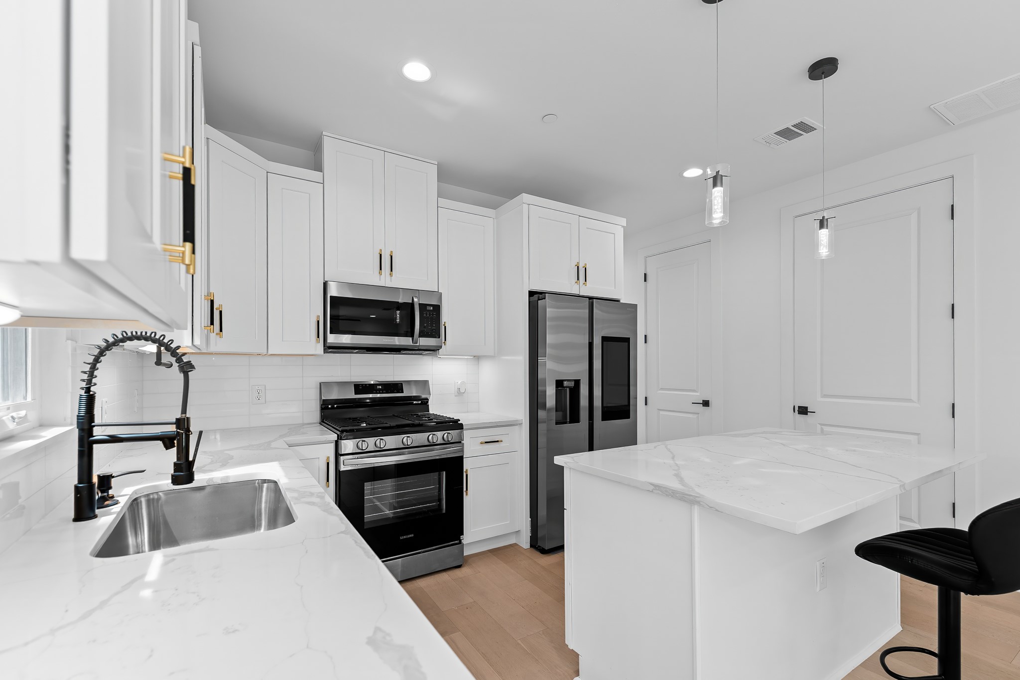 5305 Ledesma Road, Unit 4 Austin, TX 78721 - Photo 2 of 40 Culinary dreams come alive in this well-appointed kitchen, showcasing a sleek island with seating and modern appliances.
