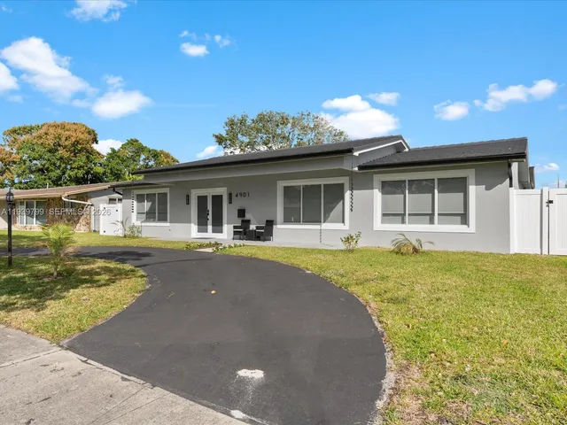 a view of a house with pool and a yard