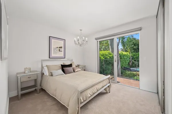 a bedroom with a large bed and a chandelier