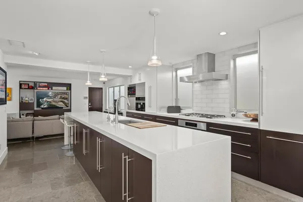 a large kitchen with kitchen island a sink a counter top stainless steel appliances and cabinets