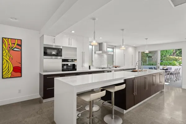 a large kitchen with a center island and stainless steel appliances
