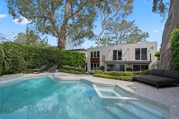 a front view of a house with a yard and trees
