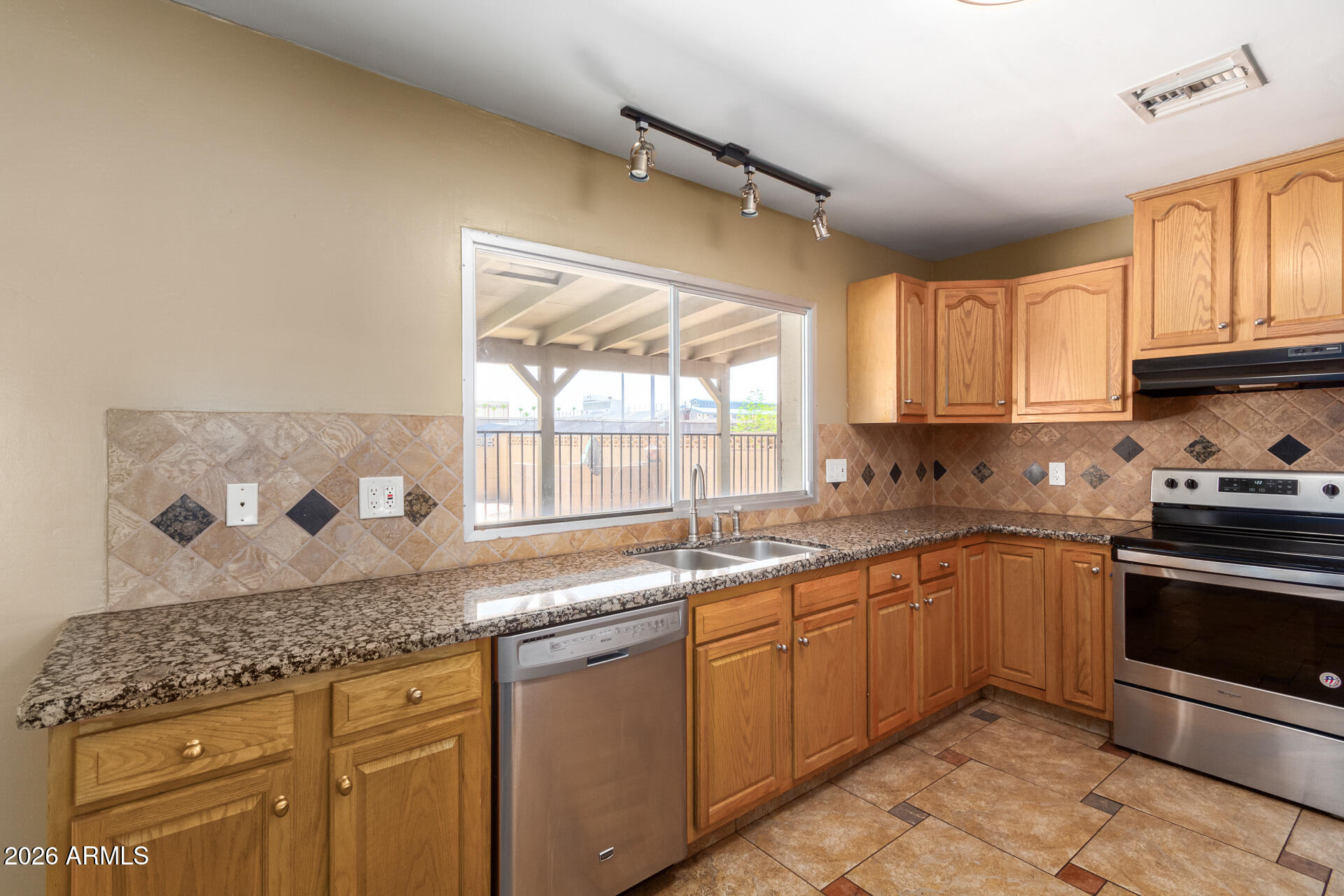 1885 East Alameda Drive Tempe, AZ 85282 - Photo 12 of 34 a kitchen with stainless steel appliances granite countertop a sink stove and cabinets