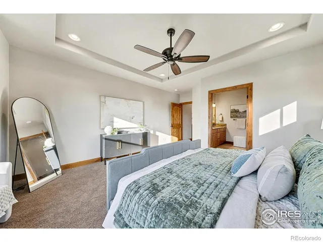 a bedroom with a bed and a mirror on the dresser