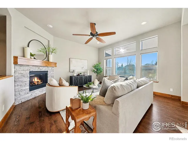 a living room with furniture a fireplace and a floor to ceiling window