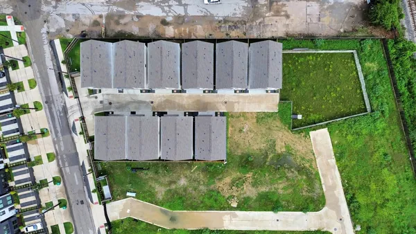 a view of a small yard with potted plants and large tree