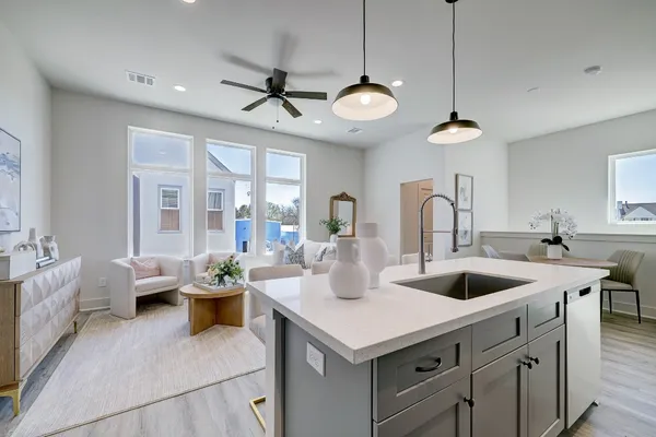 a kitchen with a counter space a sink and living room view
