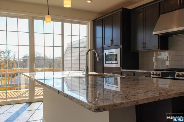 a bathroom with a granite countertop sink mirror and shower