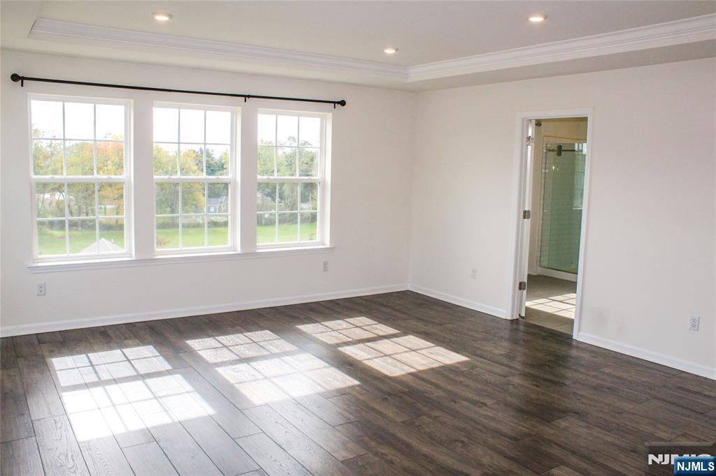 601 Charleston Drive, Unit 601 Monroe Township, NJ 08831 - Photo 22 of 45 an empty room with wooden floor and windows