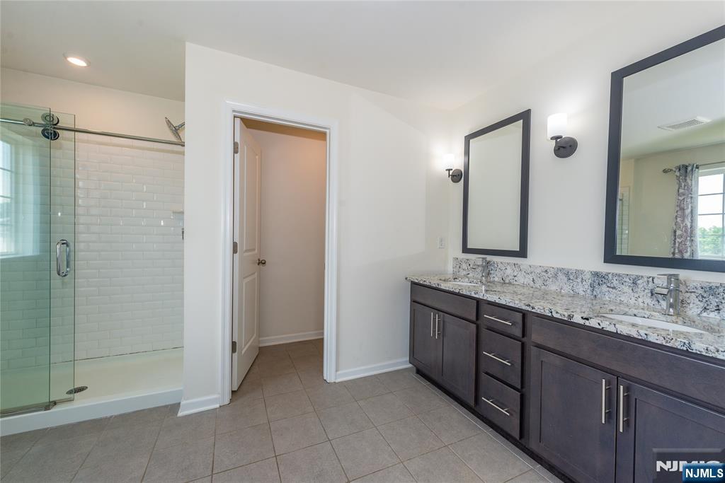 601 Charleston Drive, Unit 601 Monroe Township, NJ 08831 - Photo 23 of 45 a bathroom with a granite countertop sink mirror and shower